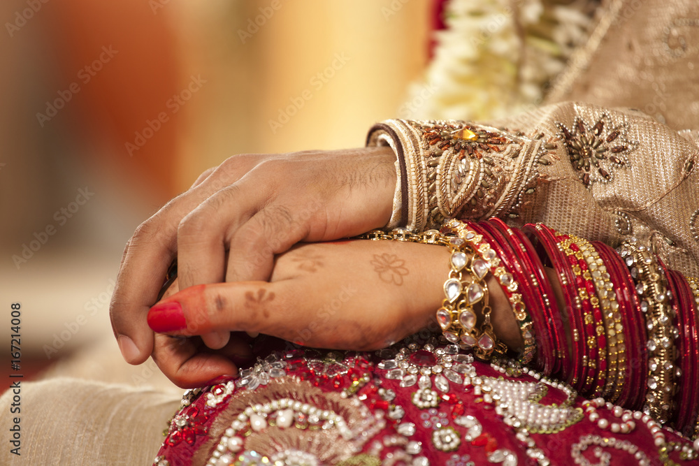 Close-up of groom holding brides hand 