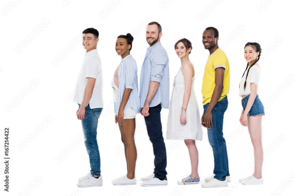 side view of young multiethnic people standing in row and smiling at camera isolated on white side view of young multiethnic people standing in row and smiling at camera isolated on white