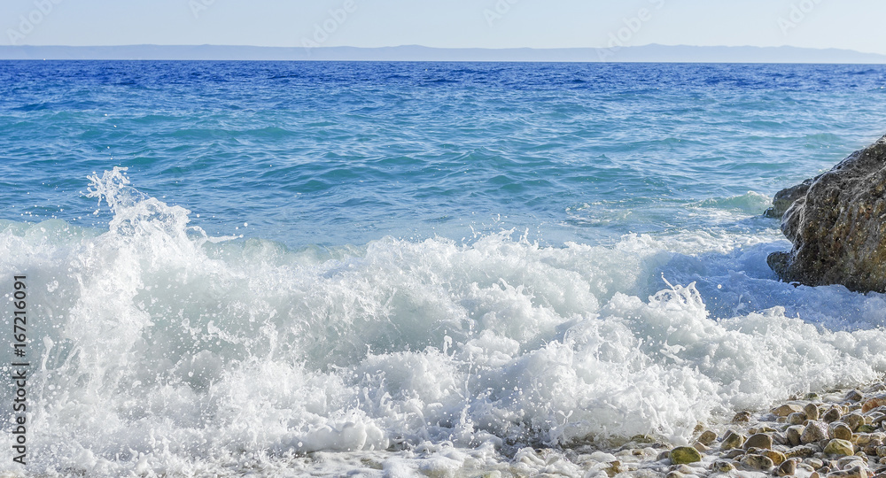 Obraz premium Sea wave is broken about stones.
