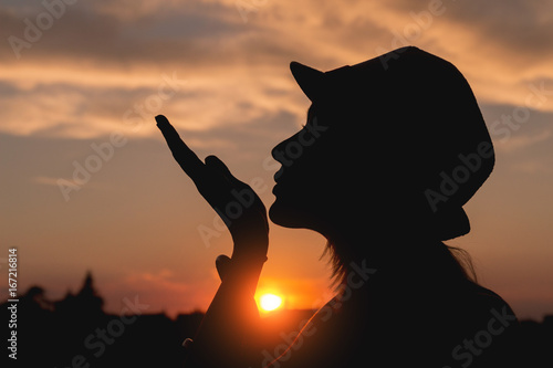 Sillhouette of a young girl enjoying in the sunset / sunrise.