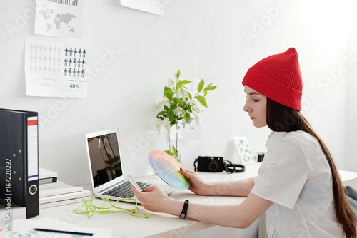 Young woman working on infographics with gadgets
