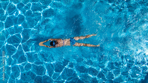 Aerial top view of woman in swimming pool water from above, tropical vacation holaday concept 