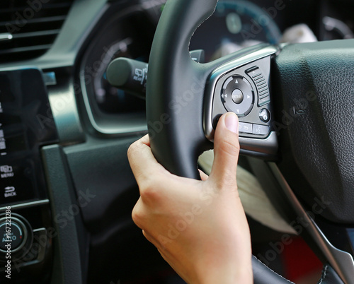Hand using Car convenient function on steering wheel. © zilvergolf