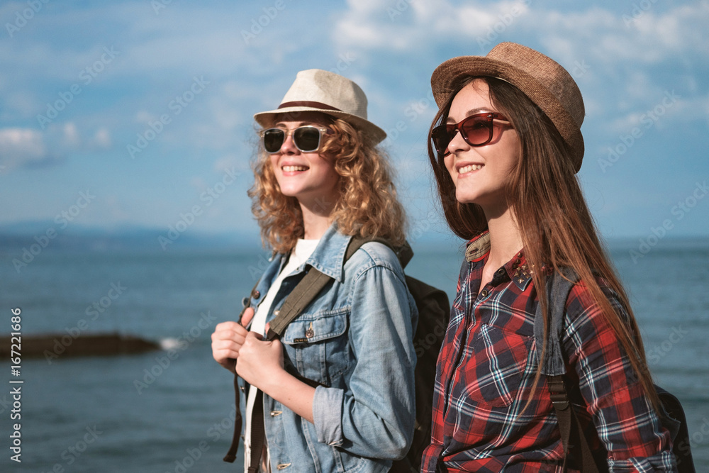 Two girls are traveling along the seashore