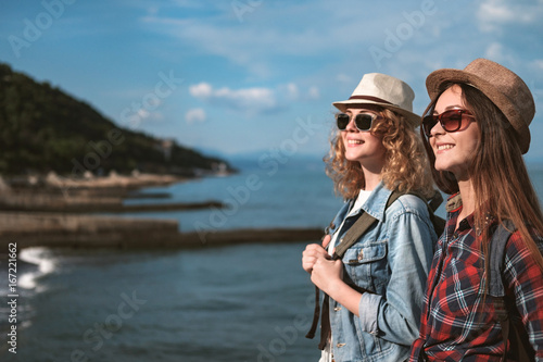 Two girls are traveling along the seashore