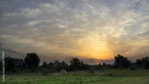 Beautiful sunrise in a field with amazing clouds. Tent. Travels.