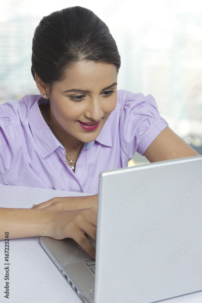 Young businesswoman using laptop at office desk Young businesswoman using laptop at office desk