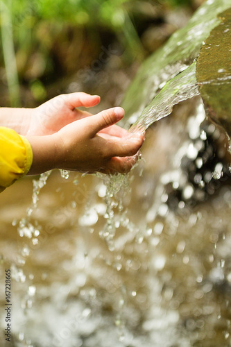 Photo of clean child hands with water splashing on them