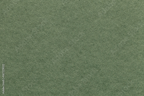 Texture of old light green paper background, closeup. Structure of dense olive cardboard