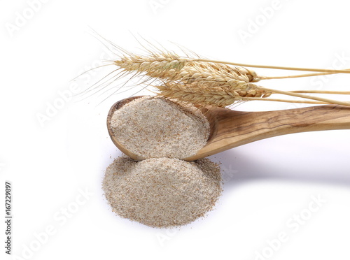 Integral flour in wooden spoon and wheat ears, with grain isolated on white background