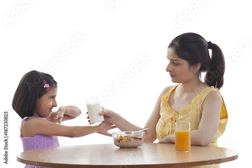 Tableau sur toile Mother feeding her daughter breakfast