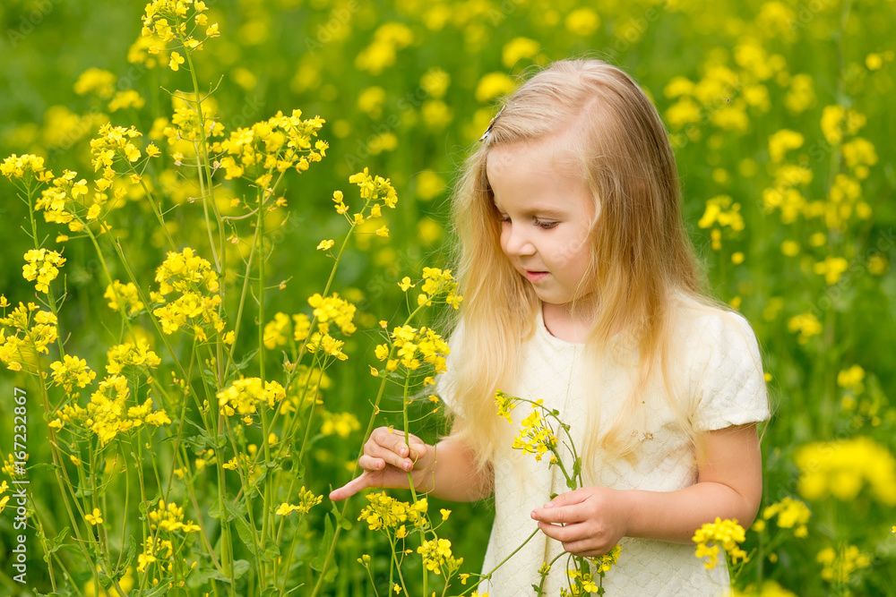 Beautiful little girl with a wreath on her head playing in a flowering field. Beautiful little girl with a wreath on her head playing in a flowering field.