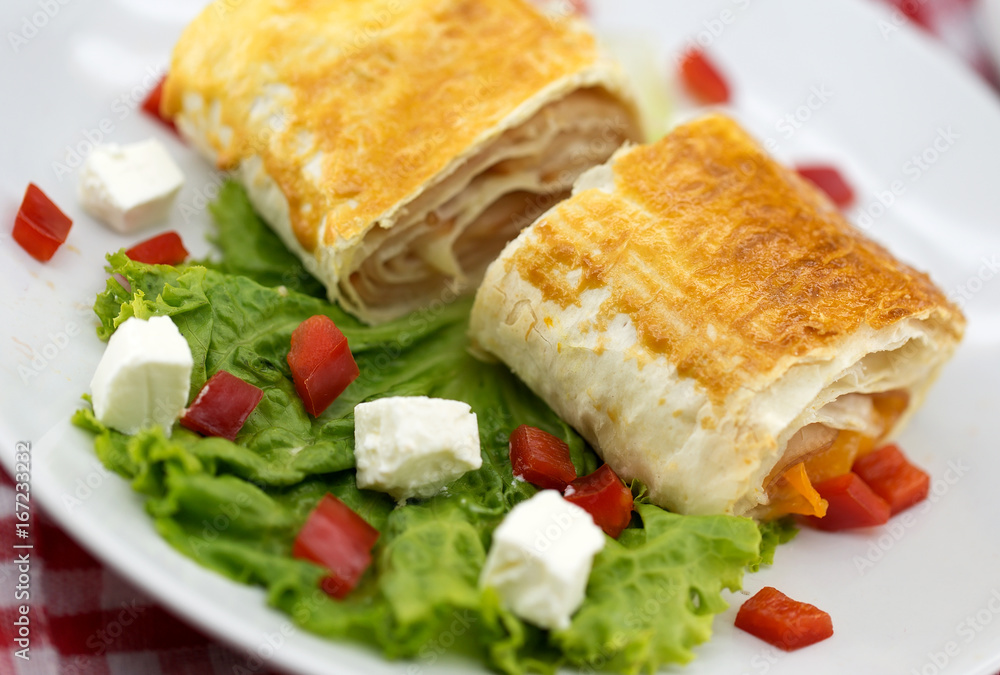 Lavash rolls with meet, vegetables and cheese served with green lettuce salad, feta chesse and red pepper on rustic wooden table. Healthy breakfast concept Lavash rolls with meet, vegetables and cheese served with green lettuce salad, feta chesse and red pepper on rustic wooden table. Healthy breakfast concept