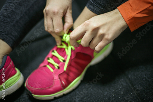 Sportswoman tying laces on sneakers.