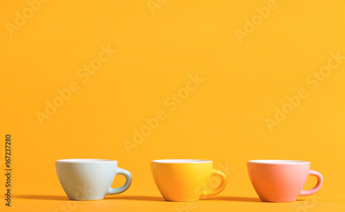 Little teacups aligned on a bright background