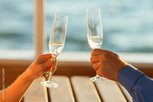 Happy couple drinks champagne on a yacht photo