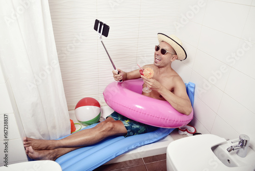 man with swim ring taking selfie in the bathroom photo