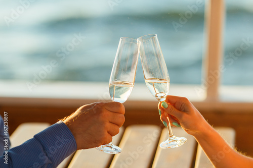 Happy couple drinks champagne on a yacht