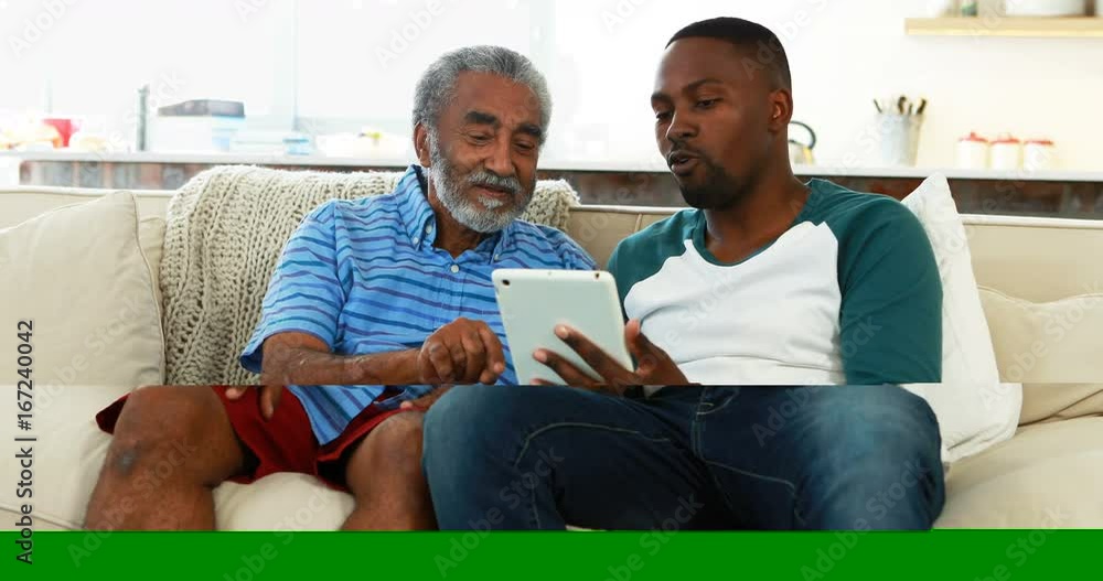Father and son using digital tablet in living room Father and son using digital tablet in living room