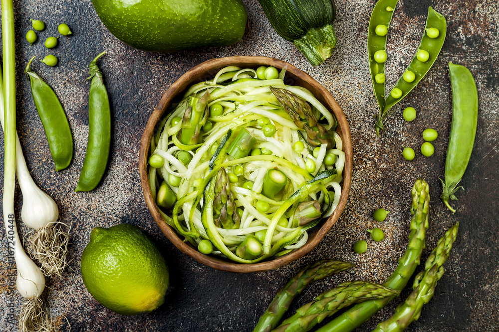 Obraz premium Zucchini spaghetti or noodles (zoodles) bowl with green veggies. Top view, overhead