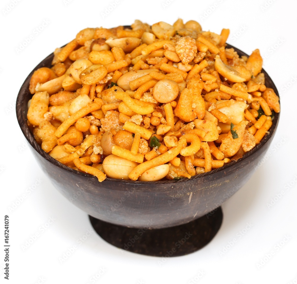 Mixture / Indian spicy snack mix served in coconut shell bowl on white background
