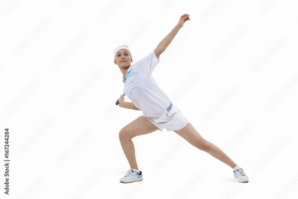 Young woman in sports wear playing badminton isolated over white background