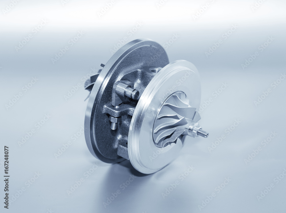 Turbocharger on metallic background. Car turbine - part of engine. Blue toned. Turbocharger on metallic background. Car turbine - part of engine. Blue toned.