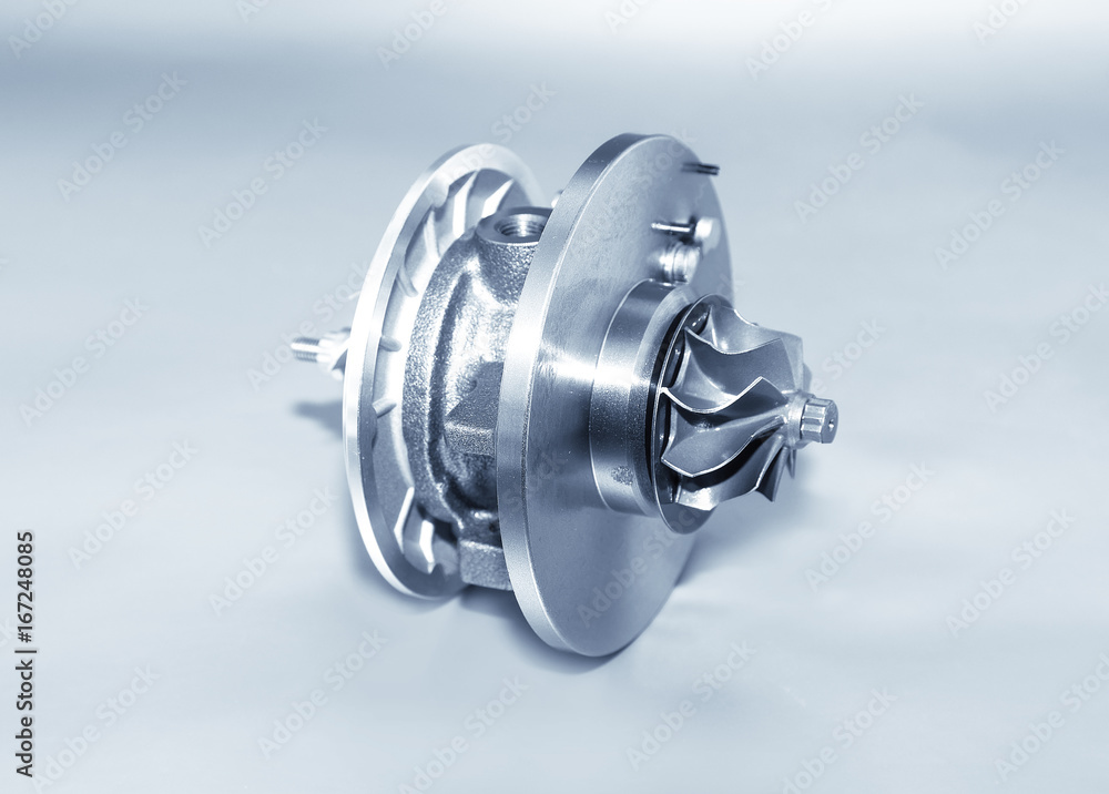 Turbocharger on metallic background. Car turbine - part of engine. Blue toned. Turbocharger on metallic background. Car turbine - part of engine. Blue toned.