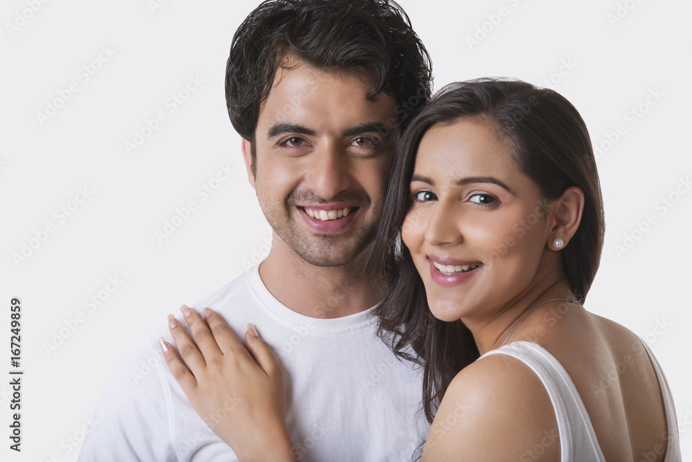 Portrait of young couple smiling against white background Portrait of young couple smiling against white background