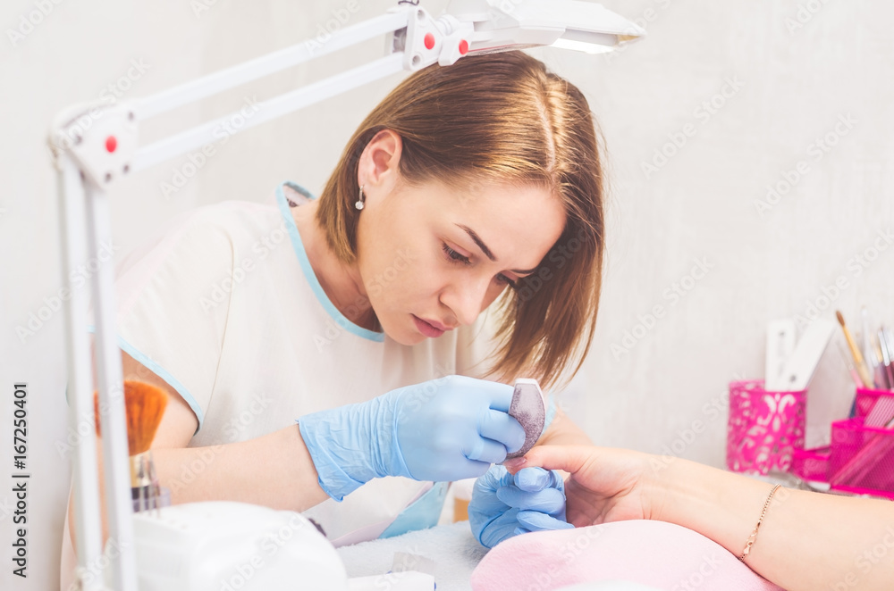 The master prepares the nails for manicure The master prepares the nails for manicure
