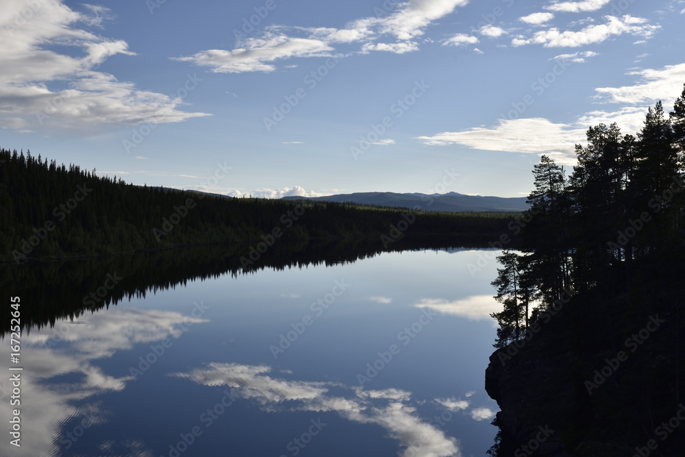 Calm lake with reflections from the sky Calm lake with reflections from the sky