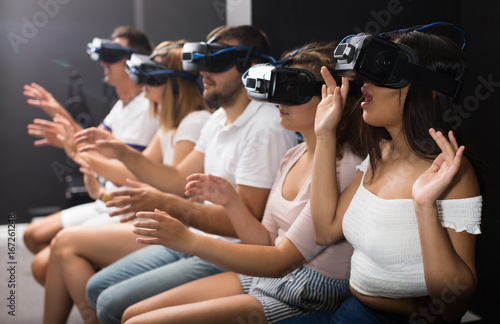 scared girl on virtual reality attraction sitting with another people