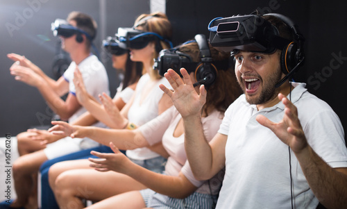 Man is enjoying exciting movie with friends in VR glasses