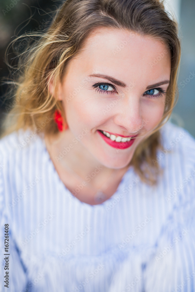 Portrait of young smiling woman with blue eyes who is outdoors Portrait of young smiling woman with blue eyes who is outdoors