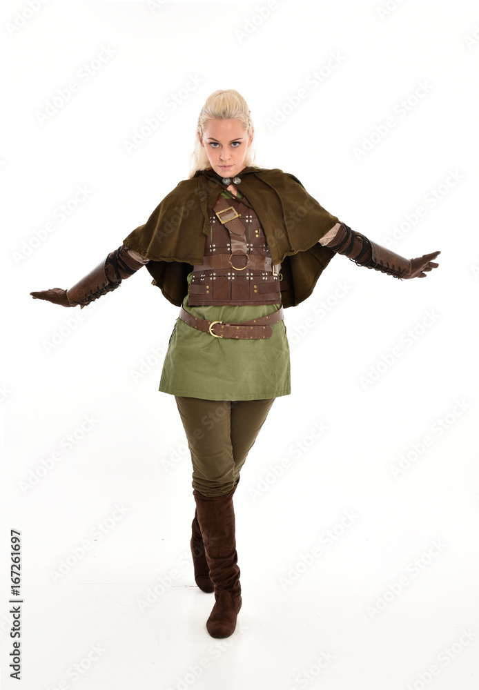 full length portrait of a blonde girl wearing green and brown medieval costume, holding a bow and arrow. isolated on white background. full length portrait of a blonde girl wearing green and brown medieval costume, holding a bow and arrow. isolated on white background.