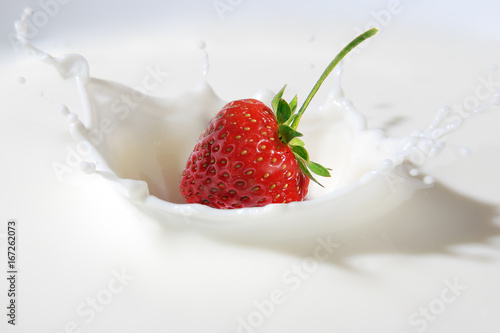 Delicious strawberry splashing into milk