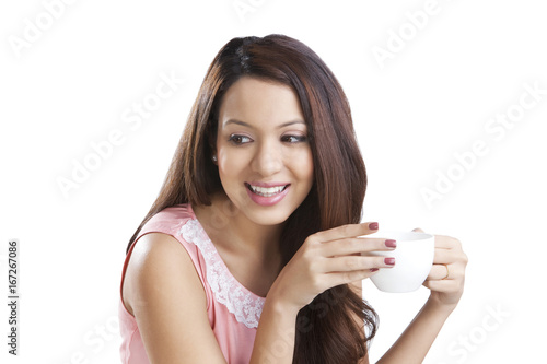 Young woman with a coffee cup smiling