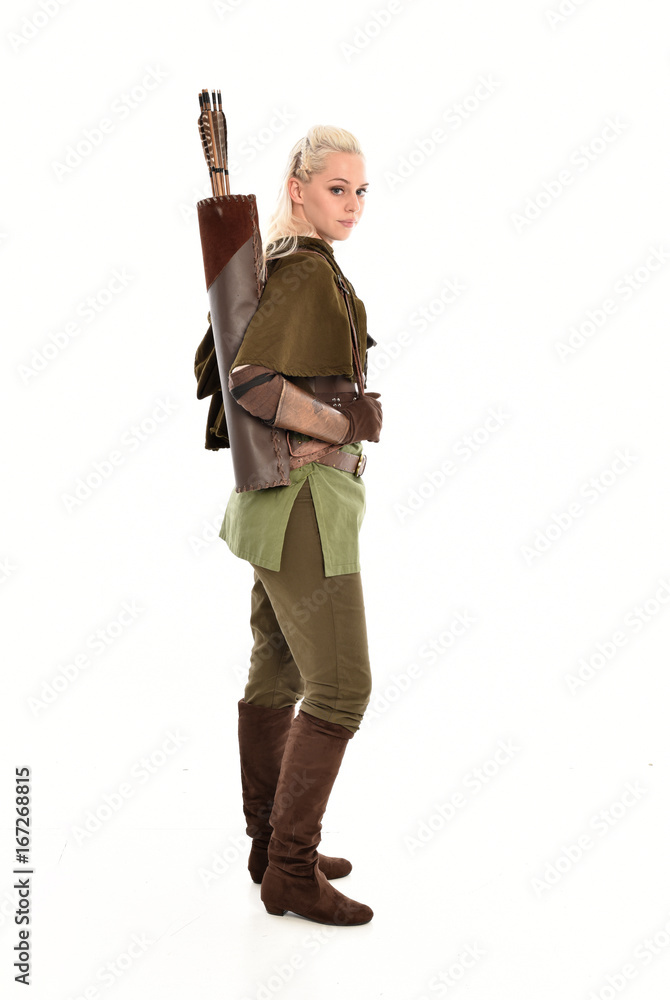 full length portrait of a blonde girl wearing green and brown medieval costume, holding a bow and arrow. isolated on white background. full length portrait of a blonde girl wearing green and brown medieval costume, holding a bow and arrow. isolated on white background.