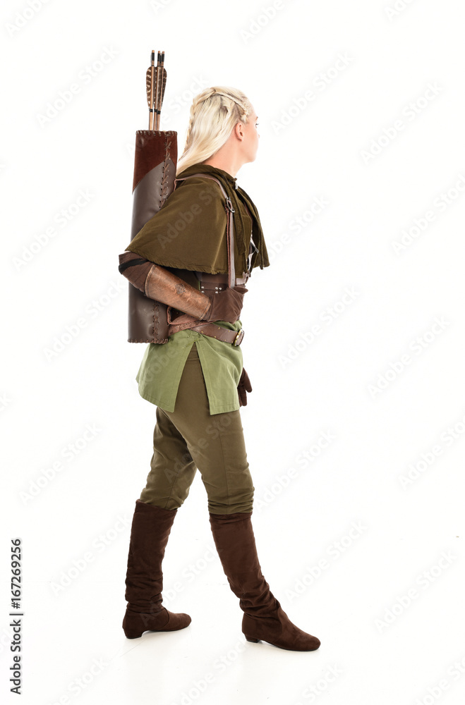 full length portrait of a blonde girl wearing green and brown medieval costume, holding a bow and arrow. isolated on white background. full length portrait of a blonde girl wearing green and brown medieval costume, holding a bow and arrow. isolated on white background.