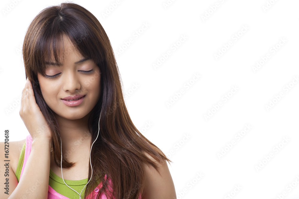 Close-up of beautiful young woman with eyes closed listening music over white background Close-up of beautiful young woman with eyes closed listening music over white background