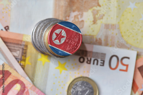 euro coin with national flag of north korea on the euro money banknotes background.