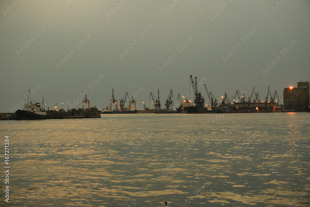 Port cranes after the sunset. Docked ships and cranes at Thessaloniki, Greece port.