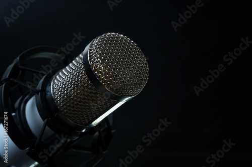 Professional condenser studio microphone on the black background