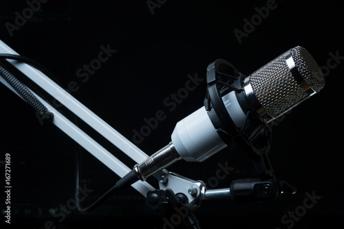 Professional condenser studio microphone on the black background