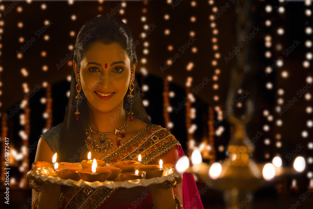 Portrait of woman holding tray of diyas Portrait of woman holding tray of diyas