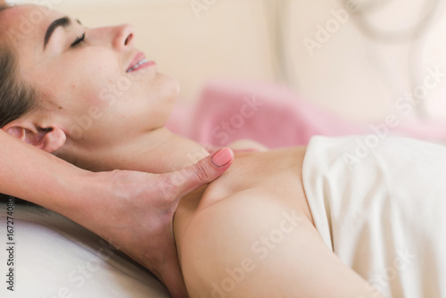 Beautiful girl having a massage in a spa center. Beautician doing massage.