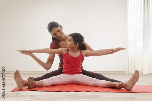 Mother and daughter doing yoga together