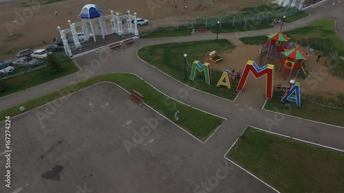 Camera Rotates over Bright Mommy Playground in Large Park photo