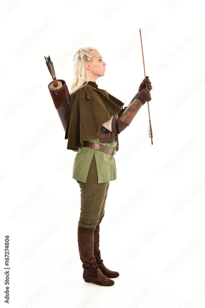 full length portrait of a blonde girl wearing green and brown medieval costume, holding a bow and arrow. isolated on white background. full length portrait of a blonde girl wearing green and brown medieval costume, holding a bow and arrow. isolated on white background.