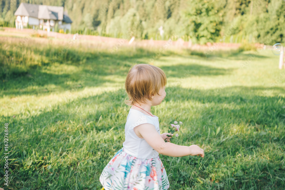 Baby girl spending time outdoor on a summer day. Baby girl spending time outdoor on a summer day.